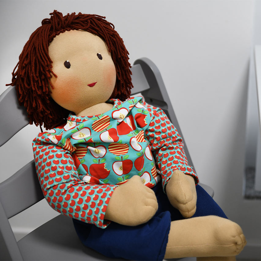 Eine Puppe sitzt auf einem Stuhl