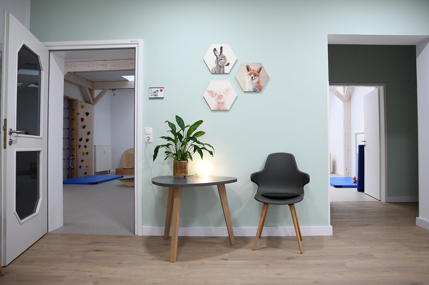 Tisch mit Pflanze und Lampe, daneben ein Stuhl im Eingangsbereich 