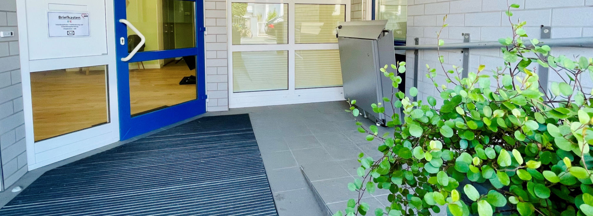 Ausschnitt der Eingangstür mit einem Teilstück der Rampe rechts