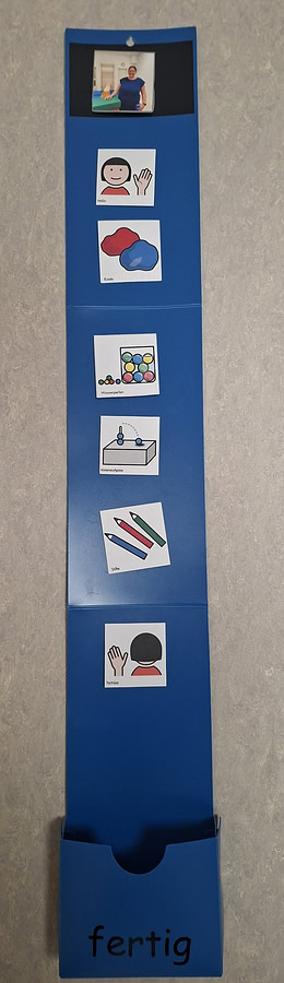 Bebilderte Kärtchen an einer blauen Hängevorrichtung